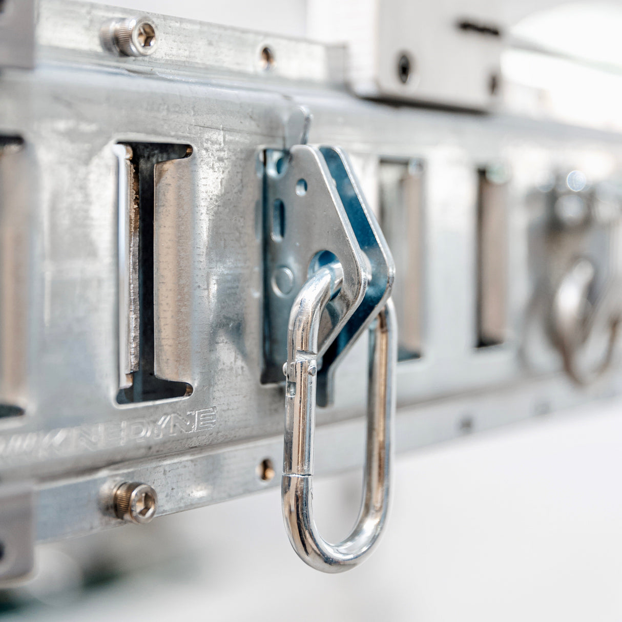 Close-up of a metal hook on an overhead garage storage rack, part of essential accessories.