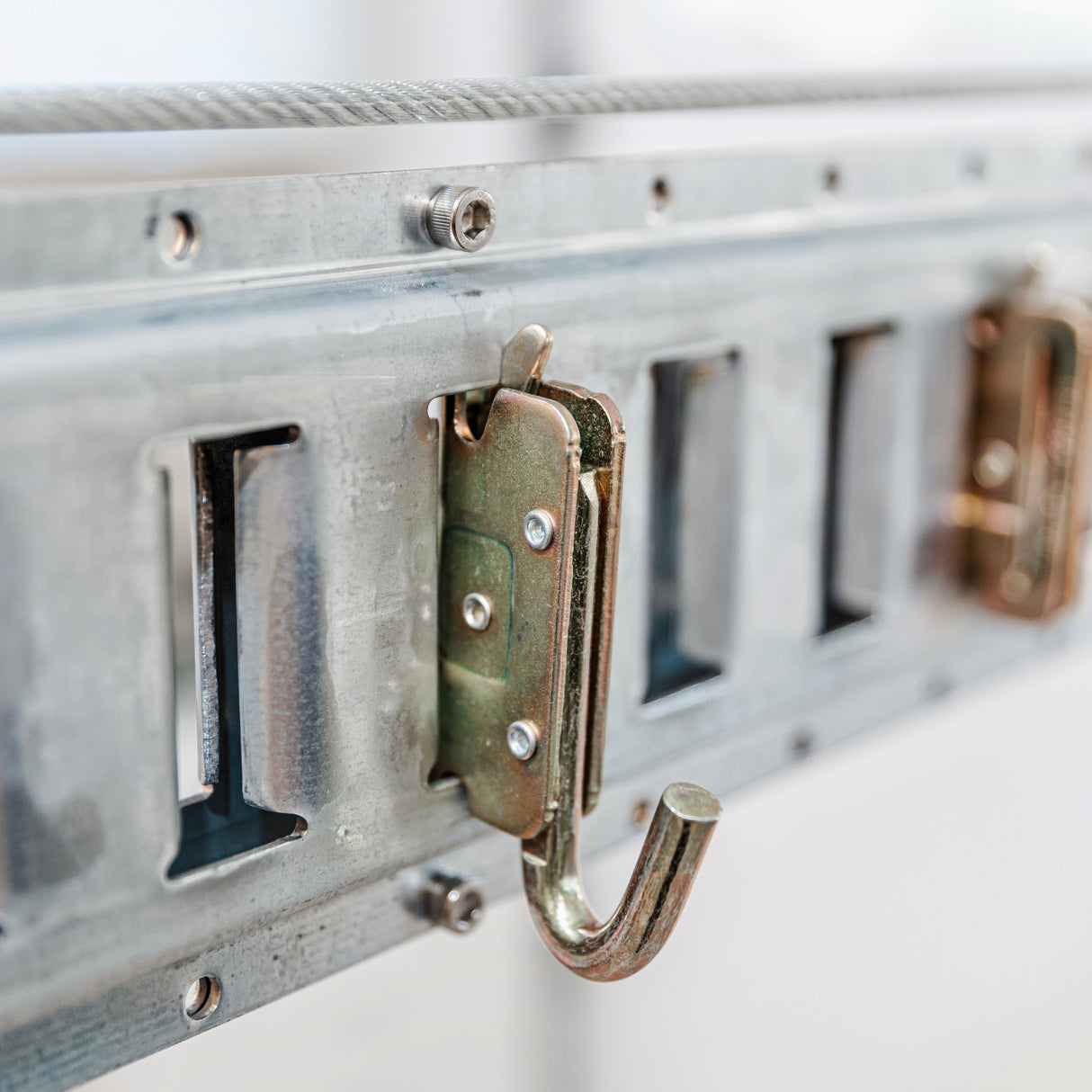 Sturdy j hook anchor mounted on a garage track for secure and versatile hanging storage.