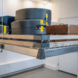 Auxx Lift motorized garage storage lift system neatly organizing luggage and boxes.