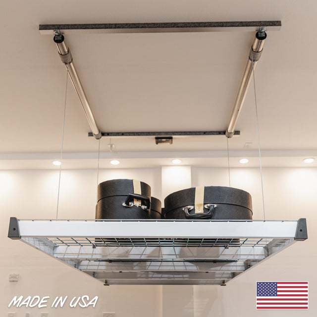 Garage storage platform holding cases, demonstrating a motorized lift system for efficient overhead storage, made in the USA.